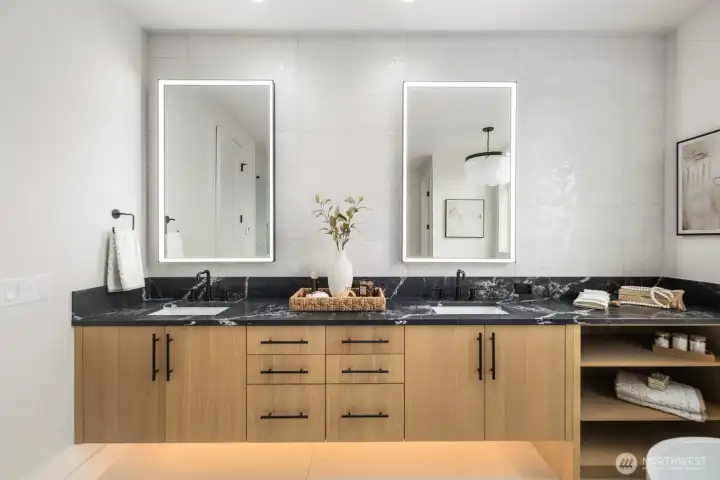 Primary bath with custom cabinet, quartz countertop, fully tiled back space and light mirrors