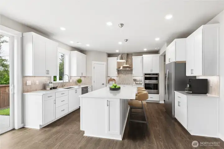 Modern open plan kitchen with slab countertops, undercabinet lighting and KitchenAid appliance package (refrigerator not included) Virtual staging.