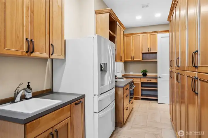 Exceptional "smart space" butler pantry includes lots of cabinetry, sink, full size fridge, and warming drawer with convection cooking option!