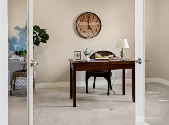Den/office with glass french doors looks out to front through wood shutters
