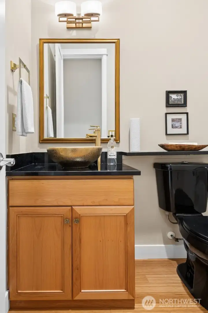 Powder bath with gold top mounted bowl sink and designer accents