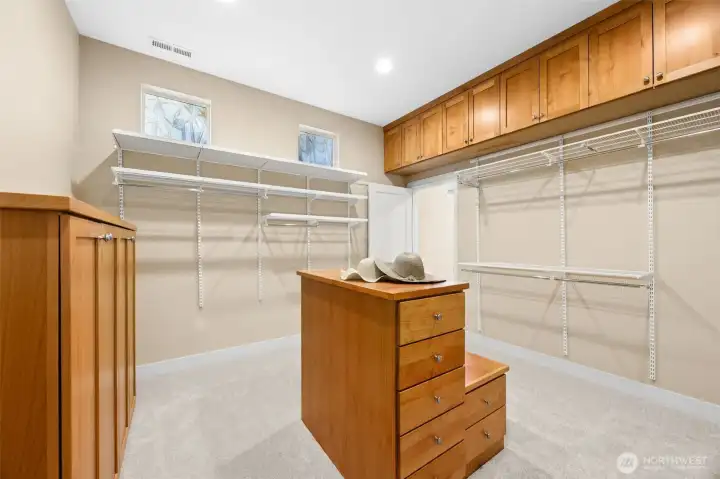 Massive walk-in closet with built-in cabinets and Elfo closet system connects to the laudry room