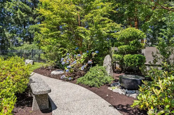 Low maintenance yard with sprinkler system and tranquil walk ways through park like setting