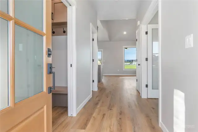 Entryway. Utility room to the left with a bench and hooks to hang your coats. To the right is the office/4th bedroom with french doors.