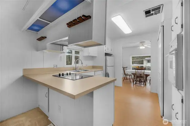 The inviting kitchen features an eat-in-bar counter and an abundance of drawers and cabinets.  The flat top range has a professional grade hood system.
