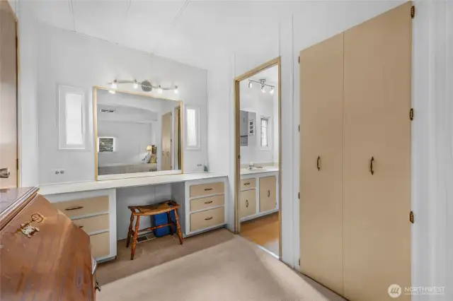 A separate makeup vanity next to the bathroom with good lighting and a large mirror. An extra closet too.