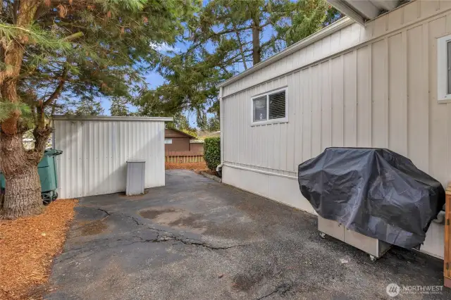 Side patio area next to the covered deck and east of the carport. Works well for the BBQ. Additional storage in the back shed which also has power.