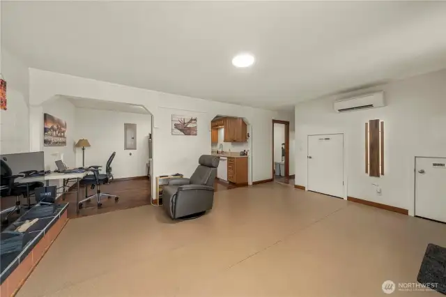 Another view of the downstairs that has laminate flooring under the laid-on protective covering. Ductless heat and AC down here as well. Under-stair storage has two doors and connects inside for a lot of storage options.