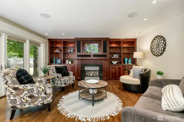 Family room with lighted bookshelves surrounding gas fireplace