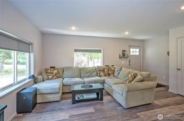 Large window bring the natural light and the new Laminate hardwood flooring throughout the entire home/Natural light pours through large windows, enhancing the beauty of new laminate hardwood flooring that spans the entire home.