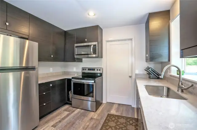 Gorgeous fully updated kitchen complete with quartz counters and modern stainless steel appliances.  Interior doorway leads seamlessly into the garage for added convenience.