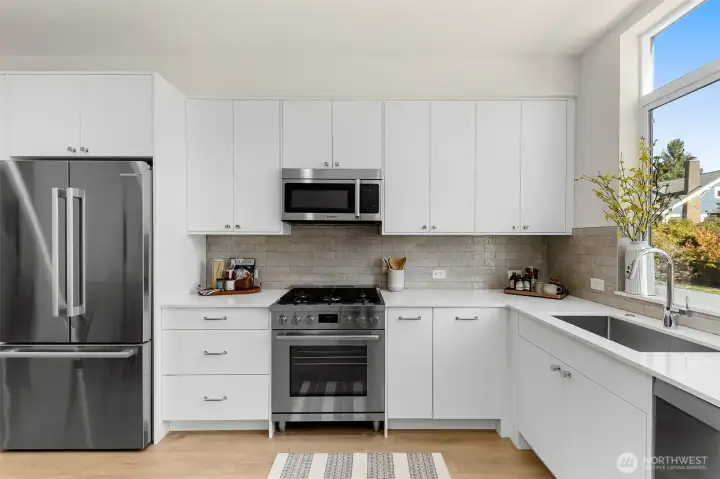 Stainless steel appliance package and modern tile backsplash elevate this culinary space with a polished contemporary edge.