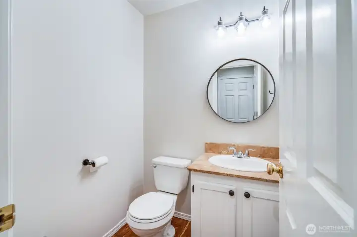 Conveniently located on the main floor, the guest powder room (half bath) features a modern vanity and toilet, perfect for visitors.