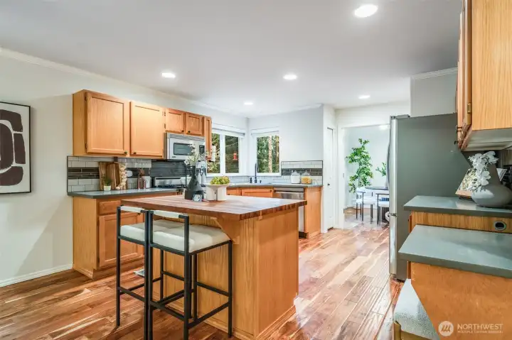 The oversized island kitchen boasts a warm wood island top and durable, attractive solid-surface countertops for the perimeter. This space seamlessly adjoins the family room.