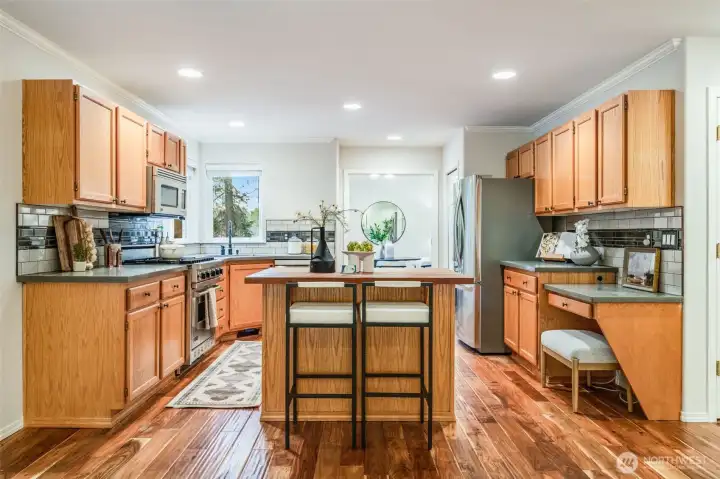 The oversized island kitchen boasts a warm wood island top and durable, attractive solid-surface countertops for the perimeter. This space seamlessly adjoins the family room.