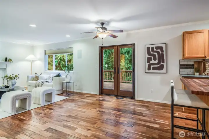 Large windows and a glass door connect the comfortable family room directly to the beautiful deck. This view emphasizes the seamless indoor-outdoor living and the privacy of the half-acre backyard.
