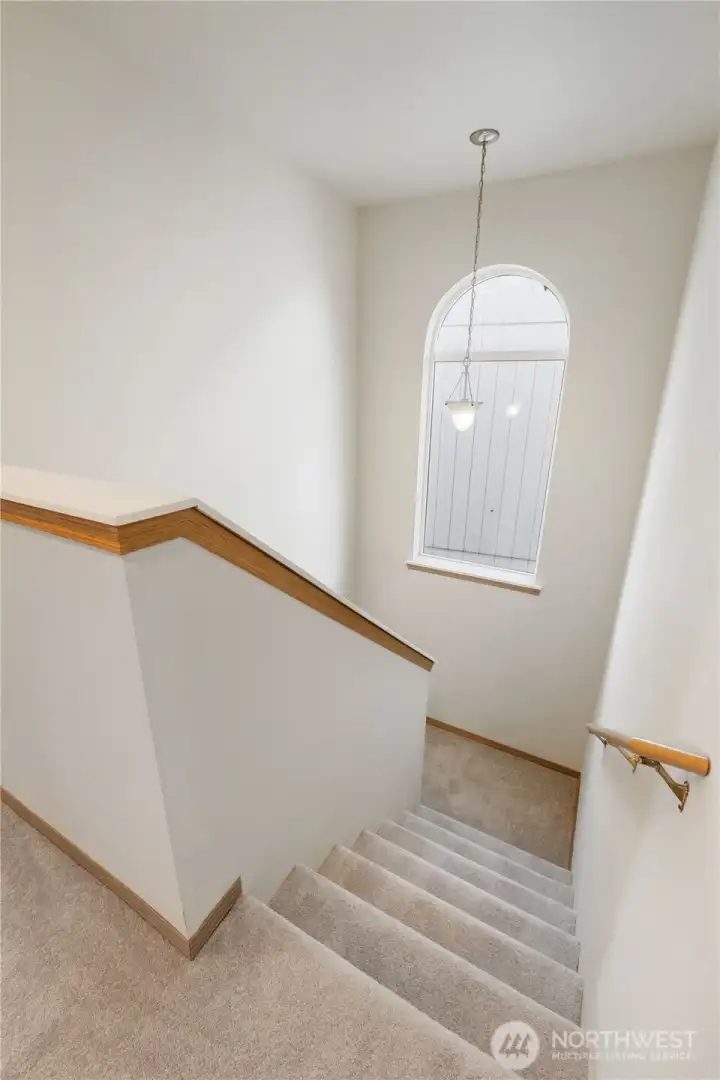 Sun-filled stairwell featuring a large picture window and beautiful natural light.
