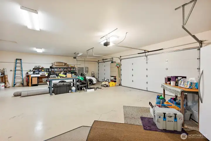 A view of the Interior of the 1298 Sq FT Attached 3+ Car Garage.Three Electrical Panels & 220, Built-in Storage!