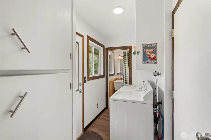 Utility room off kitchen and garage entry with half bath nearby