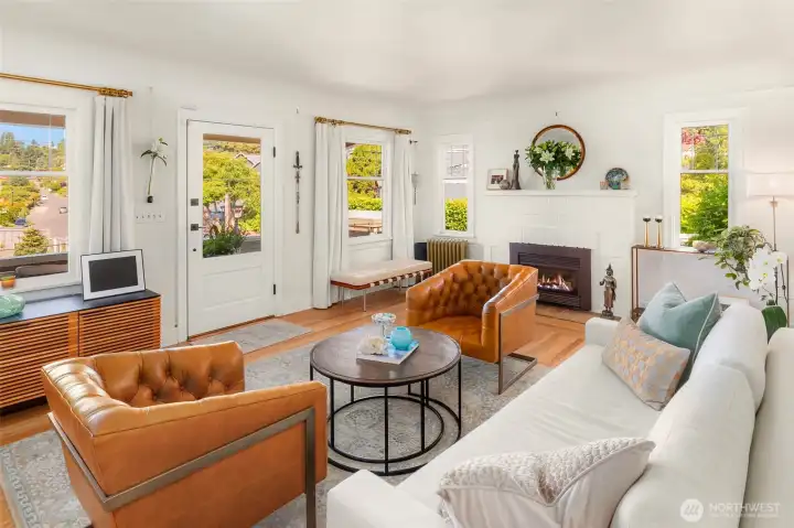 Main floor features a gracious living room opening to a covered front porch overlooking   lush gardens and water views.