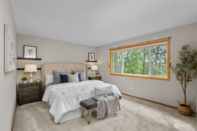 Primary suite easily fits a king bed and looks out to greenbelt views.