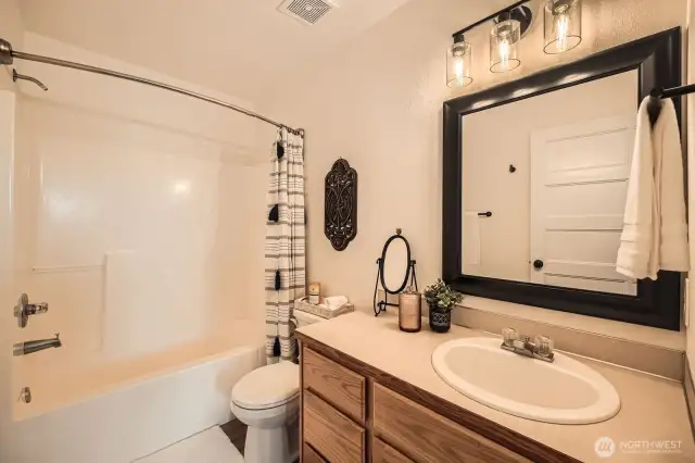 Full size bathroom connected with the primary bedroom is filled with modern touches.