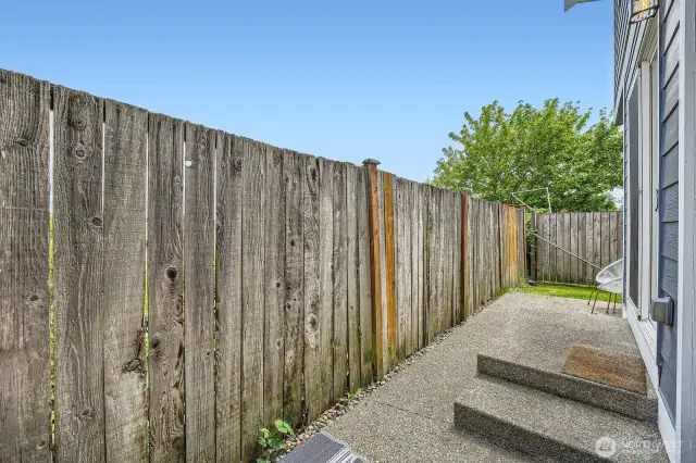 Backdoor patio is partially fenced-in. Only a very small area is open on the side.
