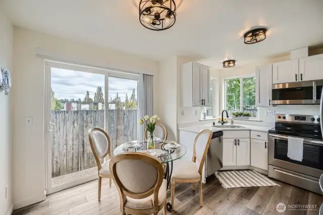 4 OF 5 TOP PHOTOS: Open kitchen with dining area has modern lighting, fixtures, and kitchen with granite countertops and stainless steel appliances.