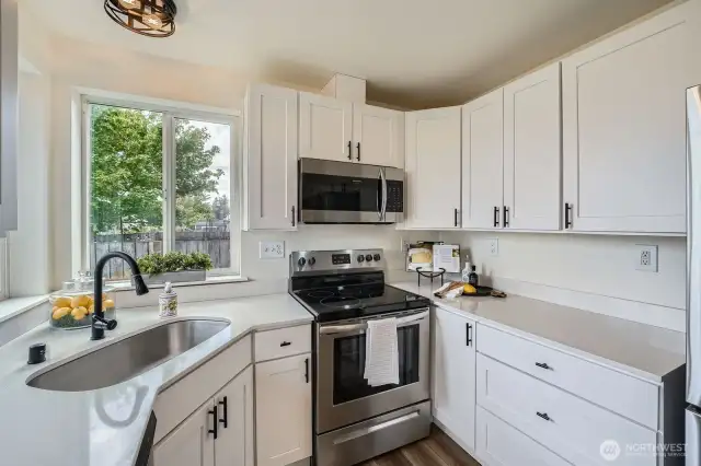 Modern kitchen with granite countertops and stainless steel appliances.