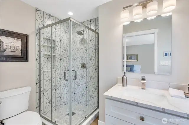 Designer tiled shower with niches for bath products. Quartz counters on slow-close cabinet drawers, decorator faucet.  Heated floors are a treat on chilly mornings!