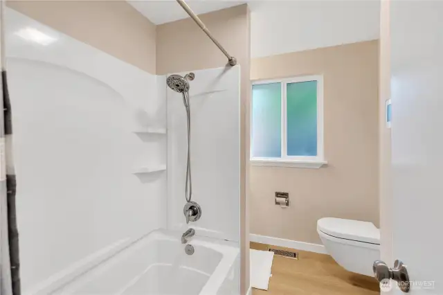 Hall Bath is a tub/shower.  Radiant heated floors!  Toilet is a wall mount, and cabinet has quartz countertop. Both bathrooms have windows and a fan.