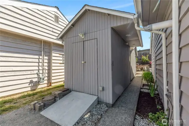 This storage structure is not connected to the house.  There is an additional structure immediately behind this one, and is accessed via the sidewalk near the back patio.  The vent at front, top right is for the tankless hot water heater installed in the garage.