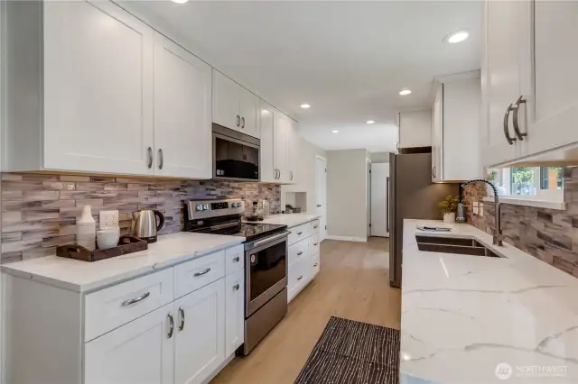 Crisp white kitchen cabinets with slow-close drawers, quartz solid surface counters.