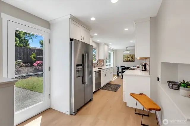 Kitchen door to the back yard steps out to the Patio, and easy access to the BBQ.  Niche seating area above could be a planner desk, study table, or add a U-line Beverage frig for juice boxes or other drinks.