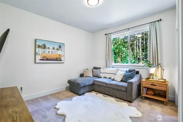 Bedroom or game room with a view of the forest and garden