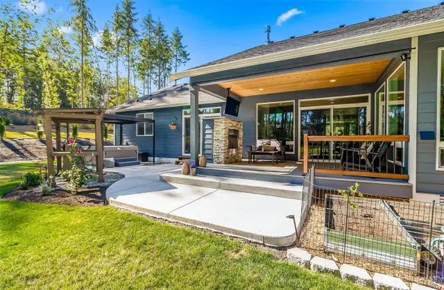 View of the back covered patio, raised garden beds that are fenced to protect your foliage