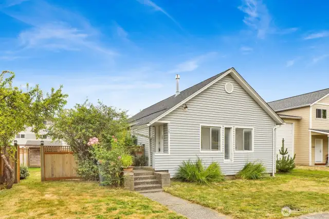 Front Door covered porch with a level lot and fenced in yard.