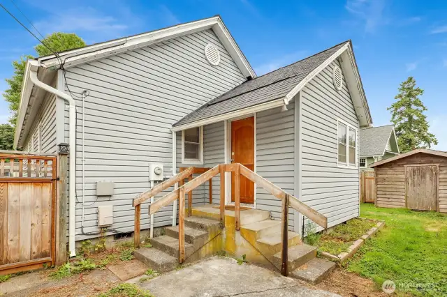 Side yard with fence and Unit 2 directly behind with alley access.