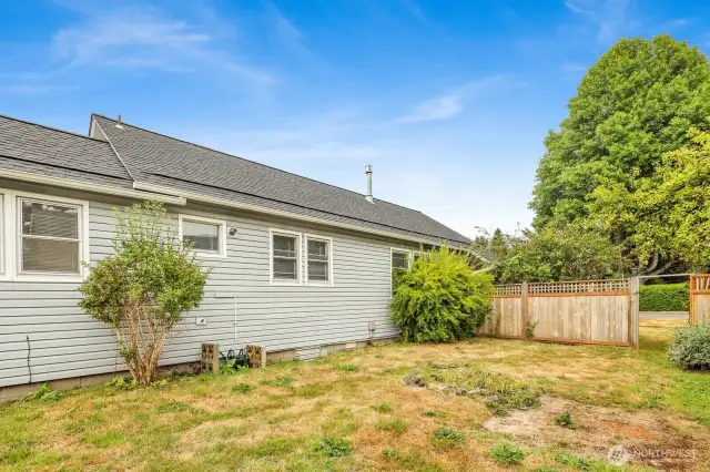 Side yard of unit 1 with gate to the front entry. Gets great all day sun and you can have a fire pit, garden, or large entertaining area.