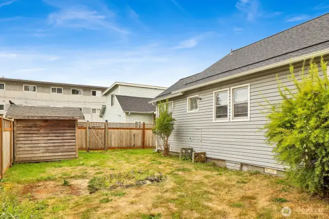 Side yard with fence and Unit 2 directly behind with alley access.