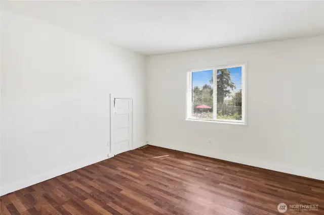Second bedroom with closet and laminate wood flooring.