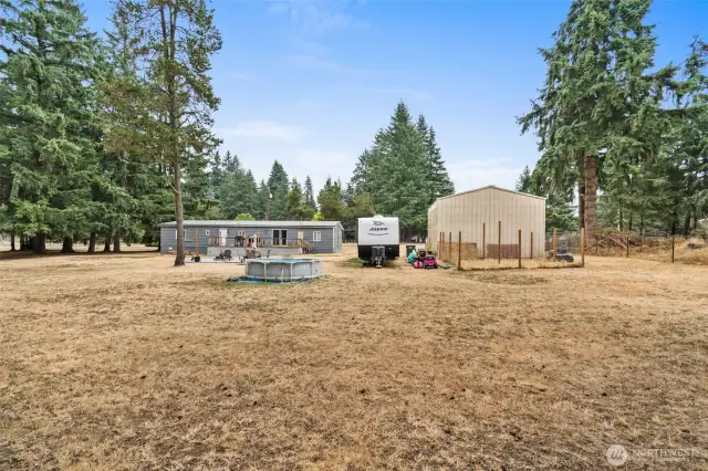 Back yard with dog kennel behind shop.