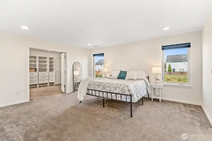 Vast primary bedroom with a view of the french door leading to the walk-in closet