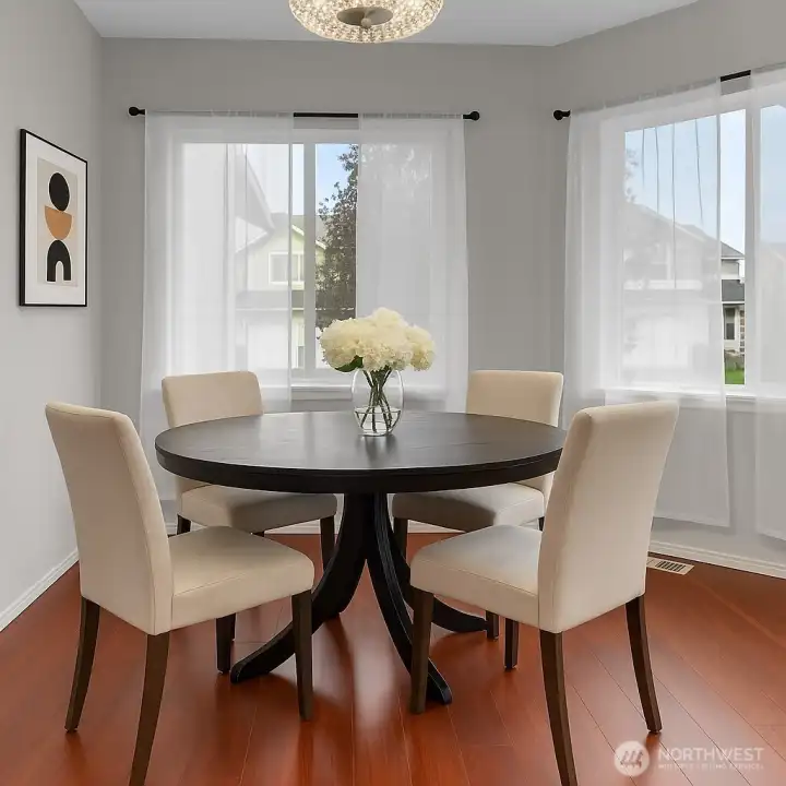 Enjoy meals in this elegant dining area filled with natural light and warm wood floors. The open layout and modern touches create the perfect space for gathering and entertaining. Virtually staged.