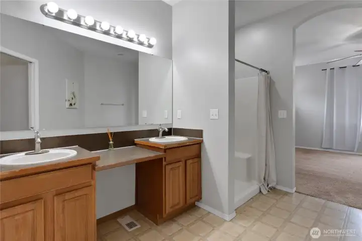 The primary bath features dual sinks, a spacious vanity, and a walk-in shower for added convenience. Thoughtfully designed to provide both function and comfort in your daily routine.