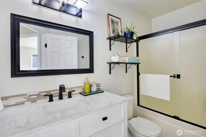 Updated vanity, backsplash, flooring, lighting and full tub/shower combo.