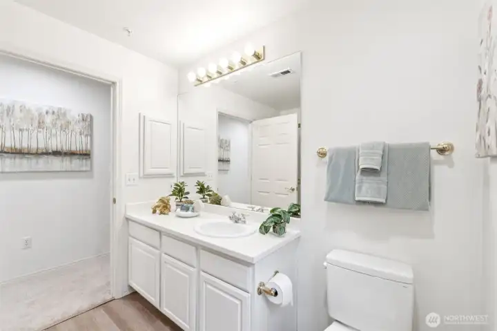 Another view of primary bathroom with door to hallway as well