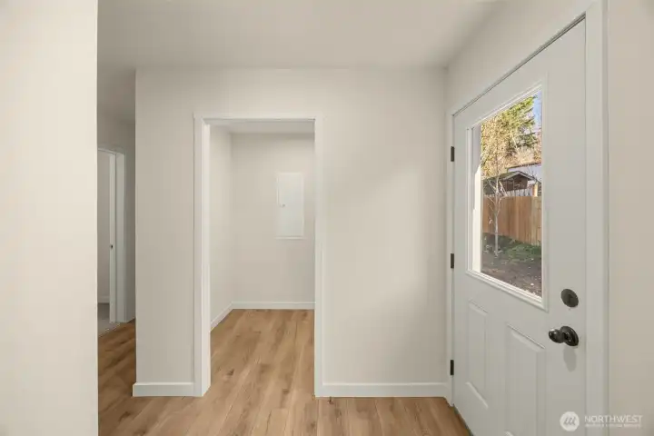 Rear entry to the right with spacious utility room straight ahead and bedrooms down the hall on the left