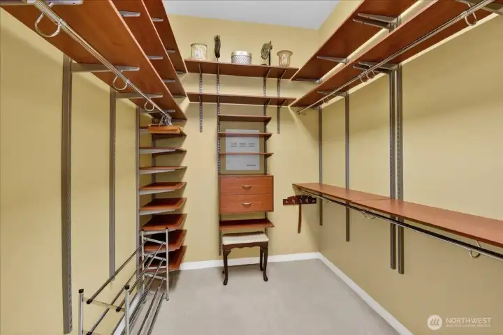 Your walk-in closet is not only spacious but smartly designed. Just look at all the shelving for sweaters, hats, shoes or whatever your needs above tons of lineage for hanging clothes.