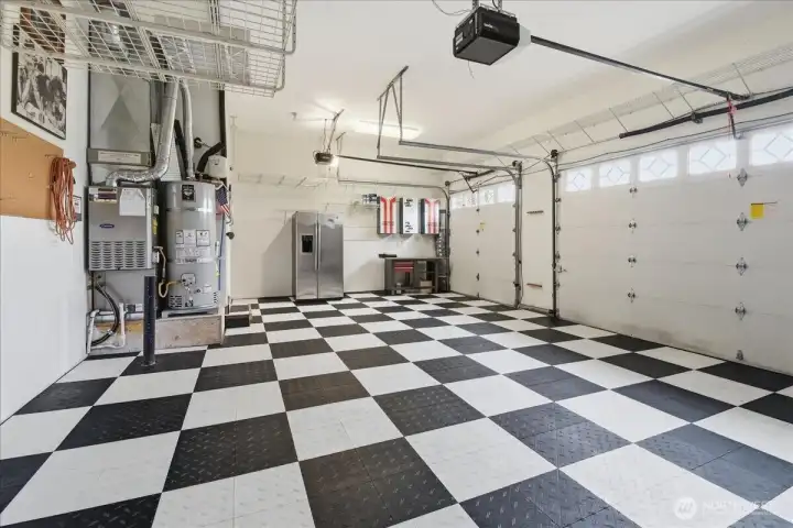 Your brightly decorated, 3-car garage hosts dual power garage door openers, loads of ceiling storage racks, wire shelving, three stylish, metal storage cabinets, work bench, 220-volt electric car charger, and a GE Profile side-by-side backup refrigerator/Freezer.